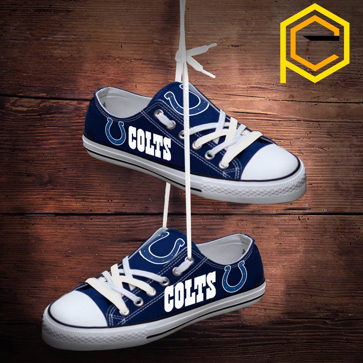 Two blue Indianapolis Colts canvas sneakers hanging by their white laces against a rustic wooden background. Highlights Colts logo and text.