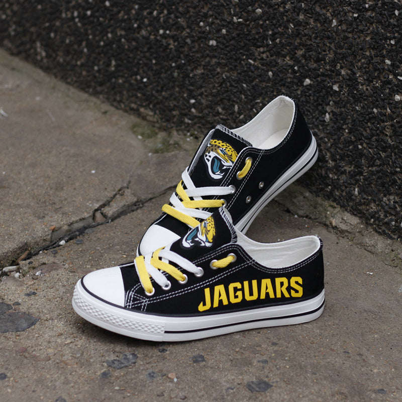 Black Jacksonville Jaguars canvas sneakers resting against a dark textured wall outdoors. Highlights the yellow 'JAGUARS' lettering and the jaguar head logo for an urban fan vibe.