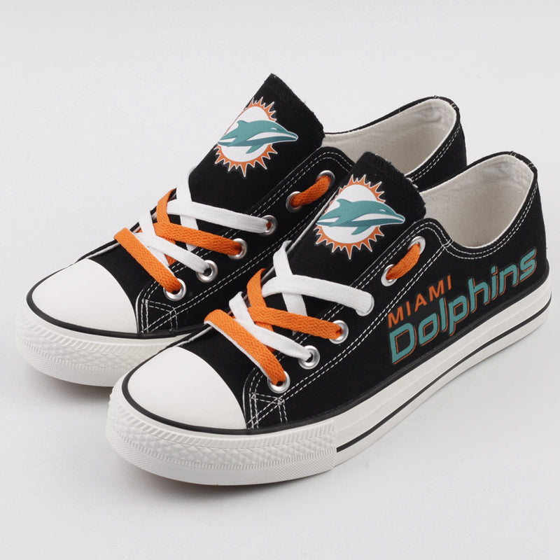 Pair of black Miami Dolphins canvas sneakers with alternating teal and white laces. Close-up view of the team logo and colors.
