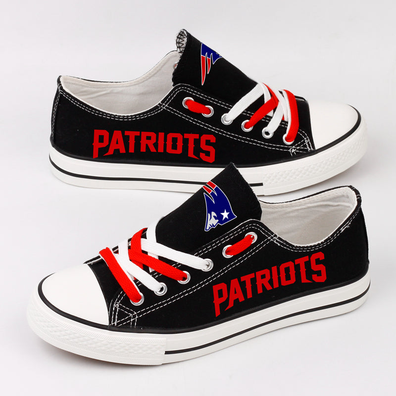 Black New England Patriots canvas sneakers showing the red "PATRIOTS" text on the side. Ideal low-top fan footwear for game day.