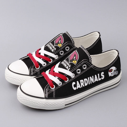 Pair of black Arizona Cardinals canvas shoes on a simple grey background. Shows the team logo, "ARIZONA CARDINALS" text, and red and white laces.
