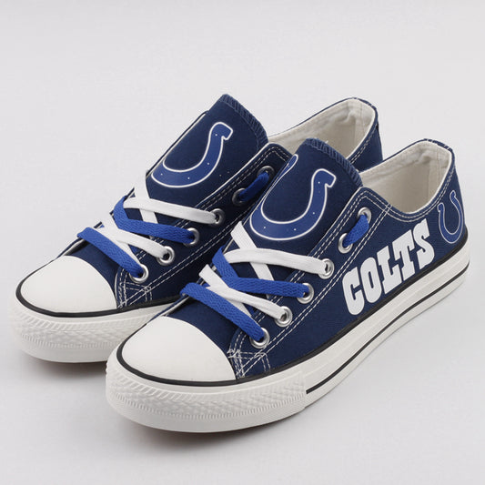 Pair of blue Indianapolis Colts canvas low-top shoes with blue and white laces. Features the iconic horseshoe logo on the tongue. Ideal NFL fan footwear.