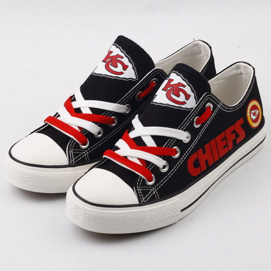 Pair of black Kansas City Chiefs canvas low-top shoes with red and white laces. Features the "KC" logo and bold red 'CHIEFS' text. Ideal NFL fan footwear.