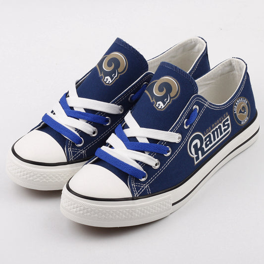 Pair of royal blue Los Angeles Rams canvas low-top shoes with white laces. Features the team's horns logo and bold gold 'RAMS' text. Essential NFL fan footwear.